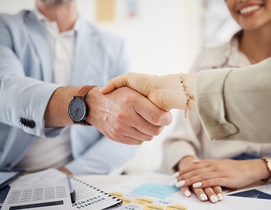 Business people, handshake and meeting in teamwork, hiring or partnership together at office. Closeup of employees shaking hands in team agreement, b2b deal or thank you in recruiting at workplace.