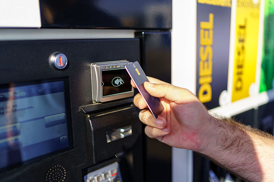 Hand of a man paying by card at a fuel pump of a gas station at high prices