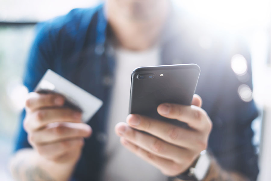 Hands holding smartphone and credit card