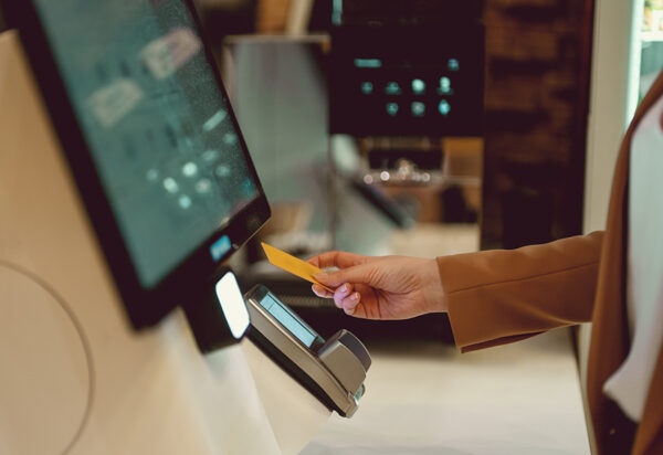 Woman pays at self-checkouts in supermarket. Woman pays at self-checkouts in supermarket.