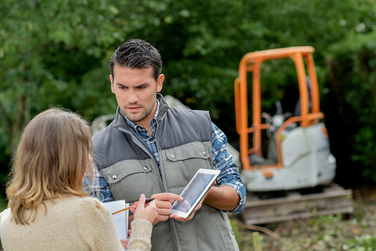 Customer and contractor in discussion, pointing to tablet screen